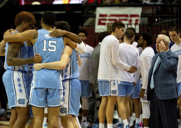 Carolina huddles together as UNC coach Roy Williams looks on. (UNC Athletic Communications)