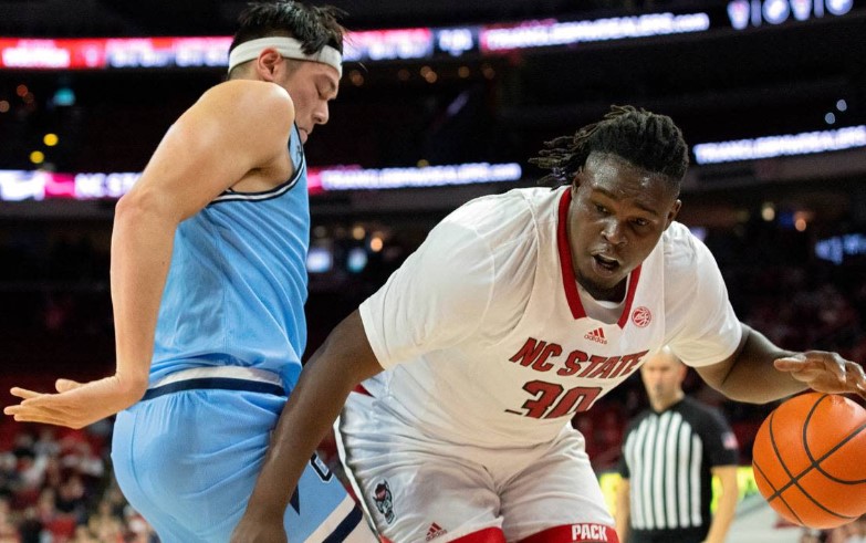 N.C. State’s DJ Burns Jr. drives baseline past the Citadel’s Quentin Millora-Brown during the first half of the Wolfpack’s season opener against The Citadel on Monday, Nov. 6, 2023, at PNC Arena in Raleigh, N.C.Kaitlin McKeown/kmckeown@newsobserver.com