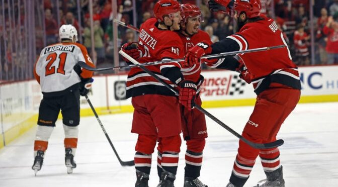 Carolina Hurricanes' Seth Jarvis, center, celebrates after his winning overtime goal with teammates Brent Burns, right, and Jake Guentzel (59) as Philadelphia Flyers' Scott Laughton (21) skates past at an NHL hockey game in Raleigh, N.C., Thursday, March 21, 2024. (AP Photo/Karl B DeBlaker) © Provided by The Associated Press